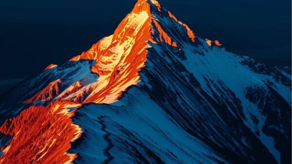 Sommet de montagne à l'aube avec lumière dorée sur les crêtes enneigées