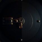 Porte de coffre-fort en acier entrouverte avec lumière ambrée filtrant à travers