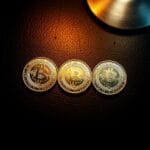 Trois pièces argentées en triangle sur cuir sombre avec finitions différentes