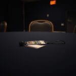 Badge de convention abandonné sur une table vide avec chaise pliée et micro débranché
