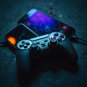 Manette de jeu poussiéreuse posée sur une surface en béton sombre.