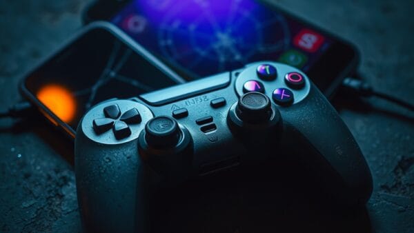 Manette de jeu poussiéreuse posée sur une surface en béton sombre.