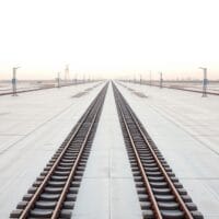 Bifurcation de rails sur une plateforme aux teintes claires, métaphore éditoriale d'un choix de direction pour Bitcoin.
